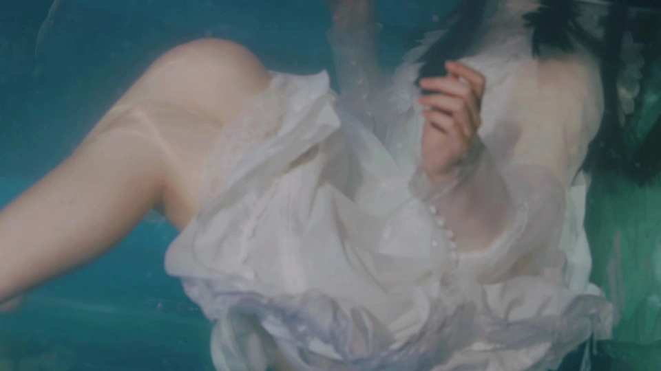 一个穿着白色连衣裙的女人在水下