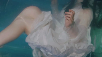 一个穿着白色连衣裙的女人在水下
