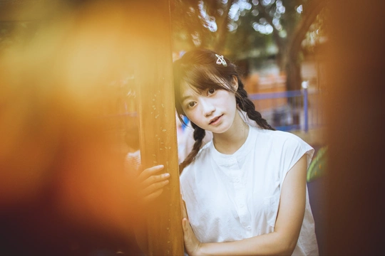 一位年轻女子站在窗前照镜子