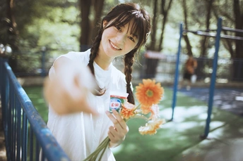 公园里的一位年轻女子抱着花