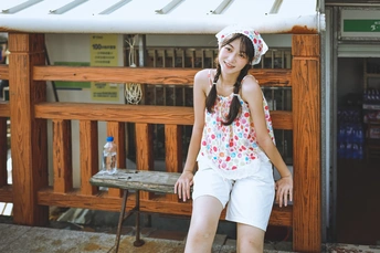 一位年轻女子戴着帽子坐在木凳上