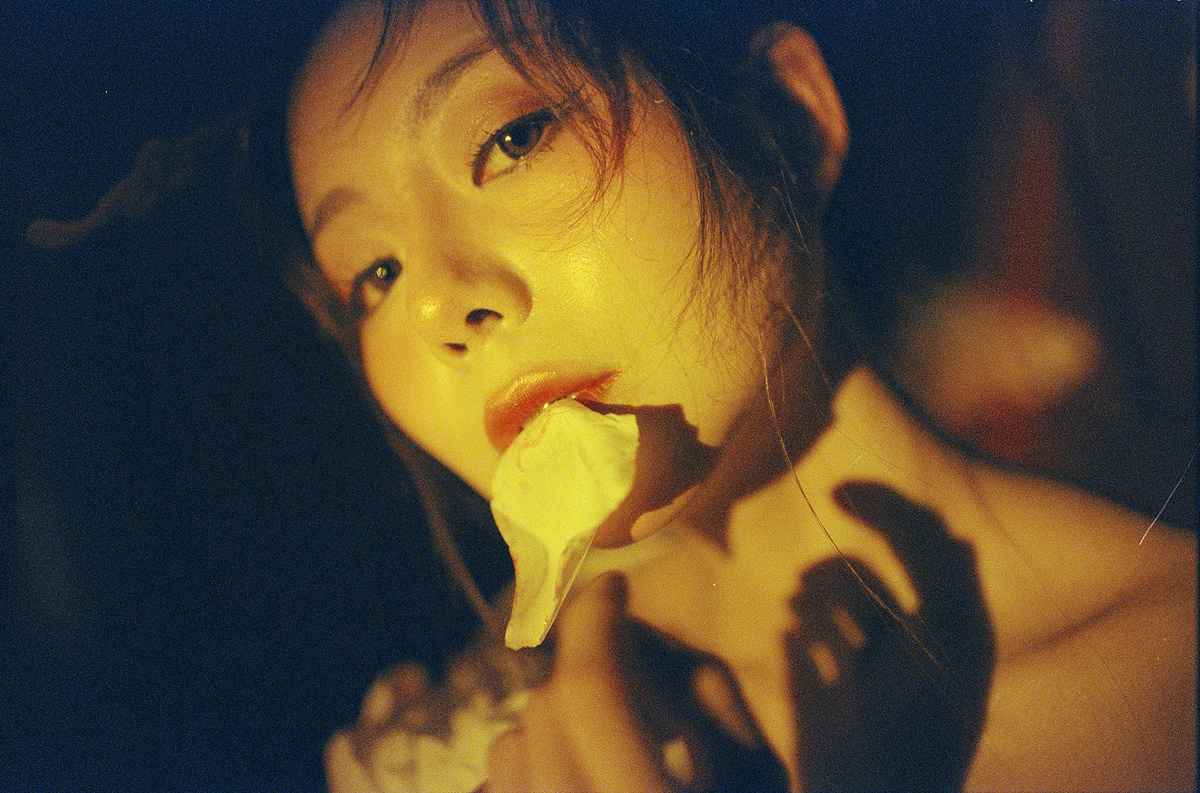 一个年轻的女人手里拿着一根香蕉放在嘴里