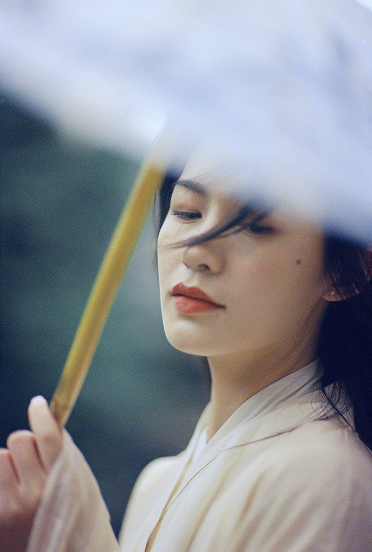 一位美丽的年轻女子手持白色雨伞