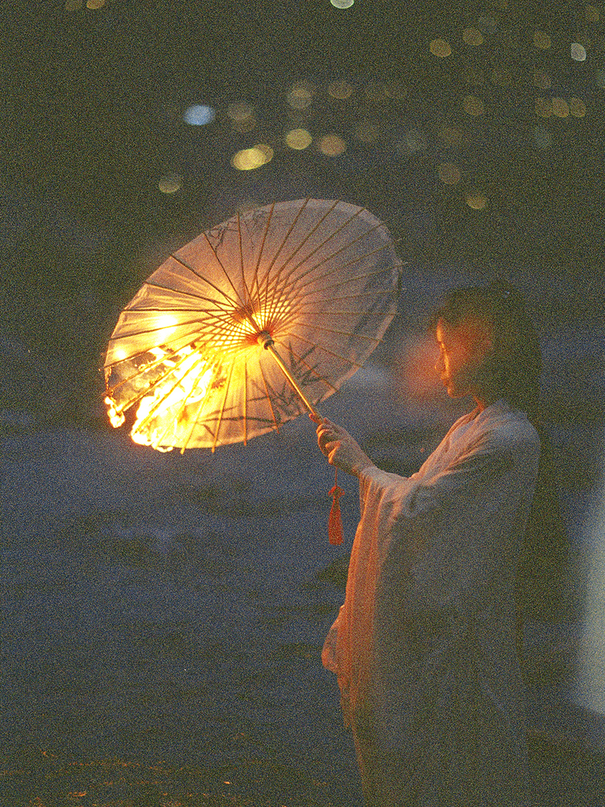 夜晚 一位年轻女子手持白色雨伞