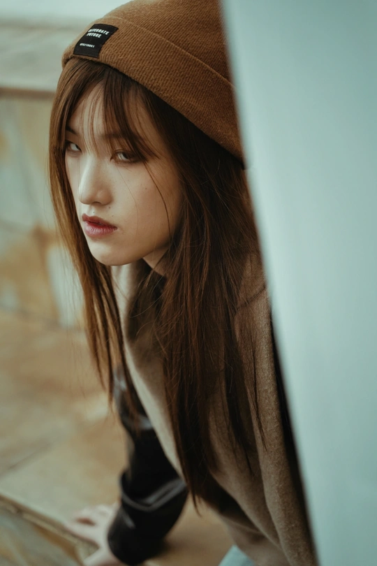 一个戴着帽子看着笔记本电脑的年轻女子