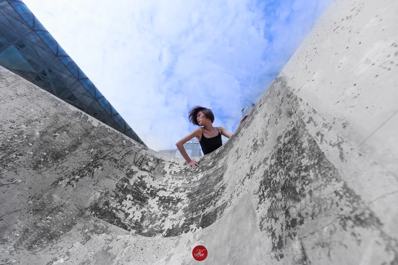 一个年轻女子骑着滑板爬上坡道