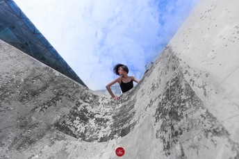 一个年轻女子骑着滑板爬上坡道