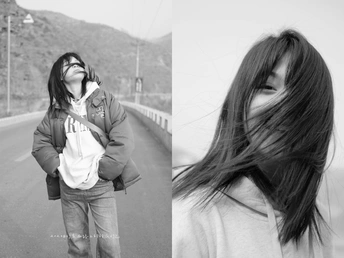 一张黑白照片 一位年轻女子站在公路中央 为拍照而姿势。