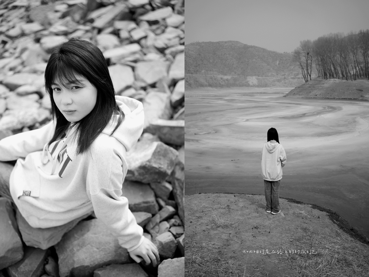一张黑白照片 一个年轻女孩站在一块岩石上