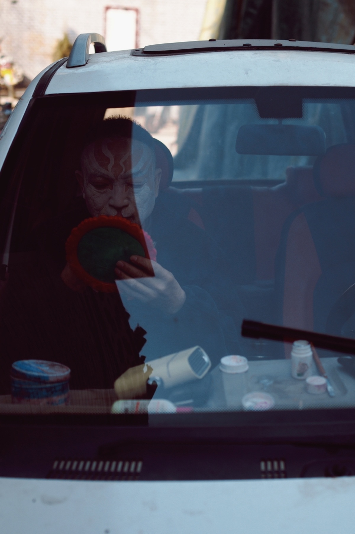 一个坐在车内 手里拿着一杯饮料的男人 和一个坐在车窗外面的女人。