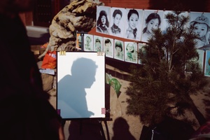 一张海报 上面有一个男人的剪影和士兵的阴影 后面有一群人站在一棵树后面。