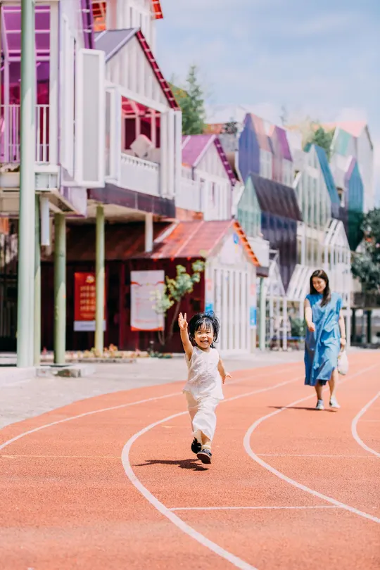 一个小男孩和一个小女孩在彩色街道上奔跑