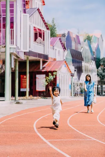 一个小男孩和一个小女孩在彩色街道上奔跑