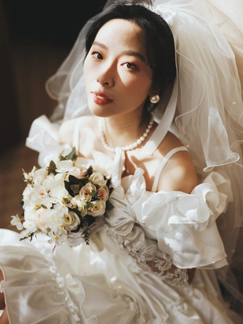 一位穿着白色婚纱的美女抱着花束的肖像