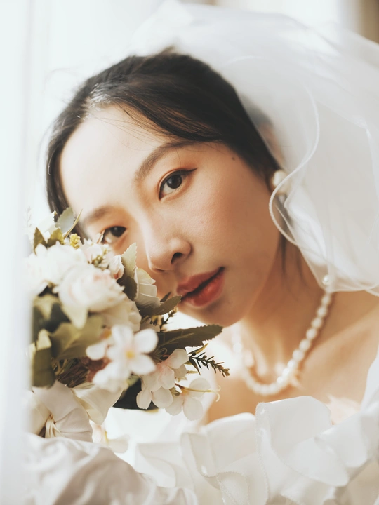 一位年轻女子手持一束白色花朵的肖像
