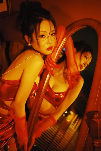 一位穿着红裙子的女人站在镜子前