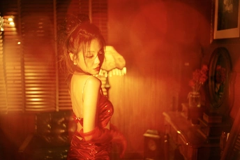 一位穿着红裙子的年轻女子站在一个房间里