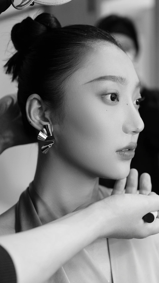 一位女士正在让一个人给她做头发造型。