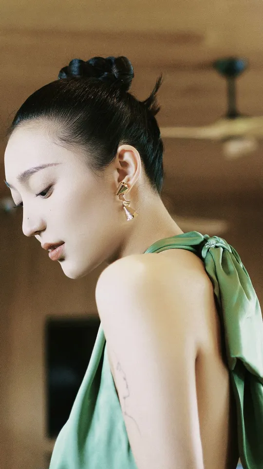 一位穿着绿色连衣裙 将头发盘起来的模特