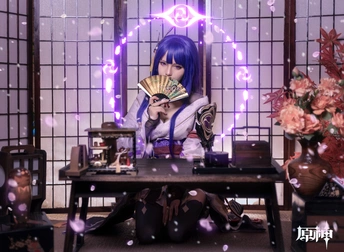 一个蓝头发的女人拿着一把扇子坐在桌子旁