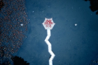 一把红色的雨伞漂浮在一个水坑里