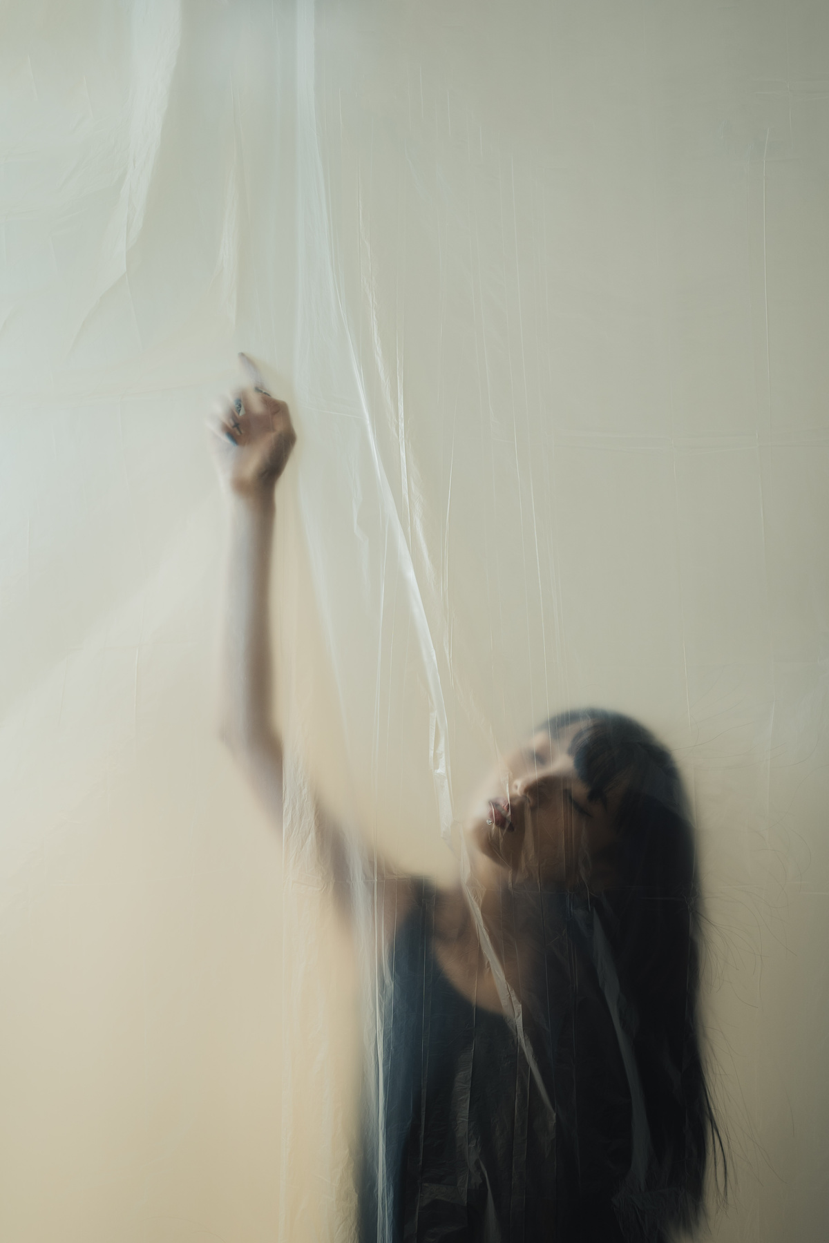 一个年轻女子站在一个有白色墙壁和塑料的房间里