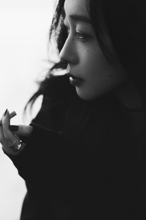 一位年轻女子吸烟 正在看手机的白黑照片