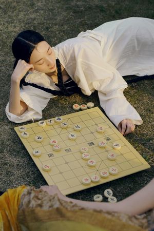 一位女子在公园的草地上下国际象棋