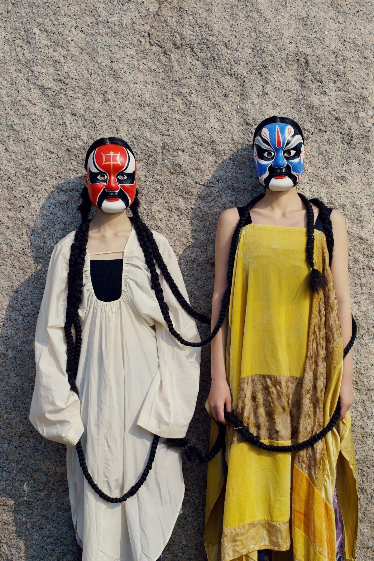 一个人和一个女人穿着 costumes 戴着面具站在墙边