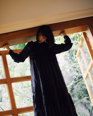 一个人穿着黑色长袍站在一个靠近窗户的房间里