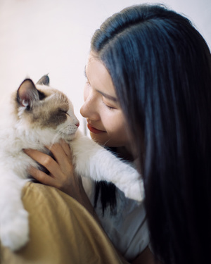 一位年轻女子抱着一只白猫