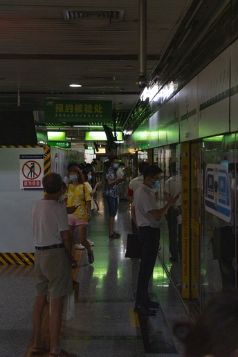 一个地铁站 很多人排队 人们走在人行道上