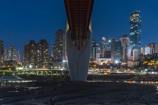 一张夜间拍摄的城市天际线照片 摩天大楼亮起 桥下有一条河