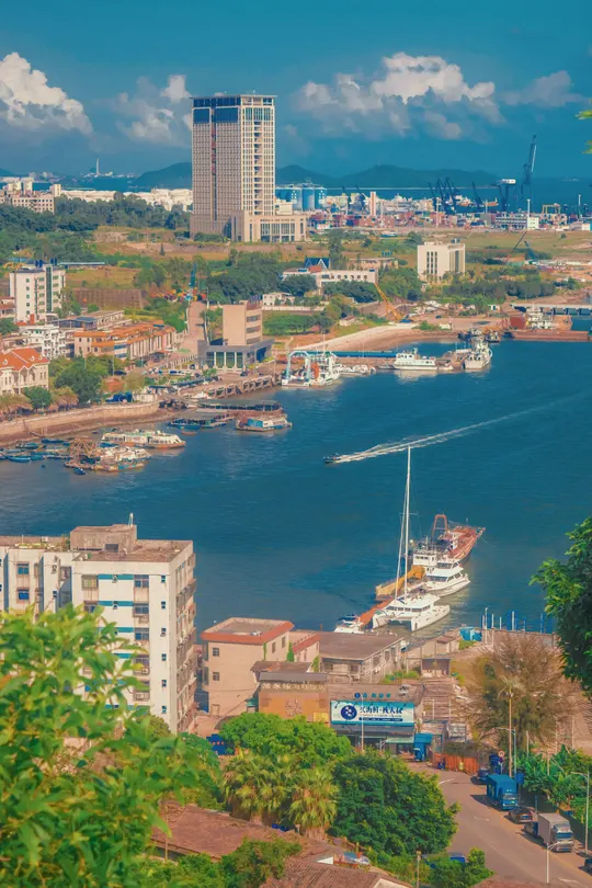 一个大水域 有船只停泊在湾里 背景有建筑。