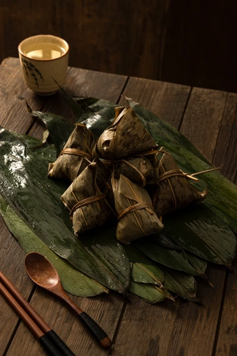 一个木制桌子 上面放着一盘食物 一杯茶或咖啡 筷子 以及一个碗。