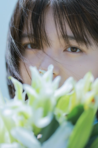 一个小女孩嘴里叼着一束白花