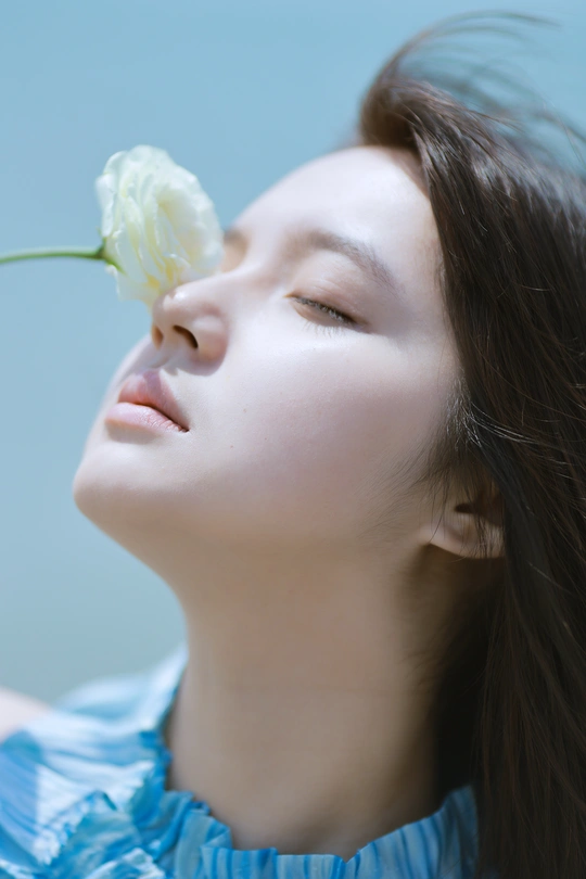 一位年轻女子手持白玫瑰的特写肖像