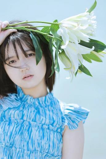 一位身穿蓝色连衣裙、头上戴着白花的年轻女子的肖像