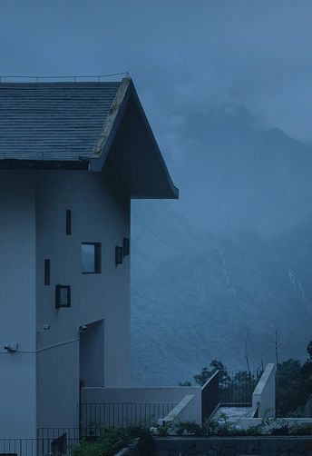 黄昏或夜晚屋顶上有云和雾的房子