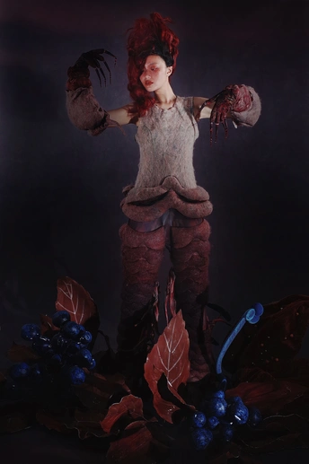 一位女士用一些叶子作为她的艺术作品摆姿势。