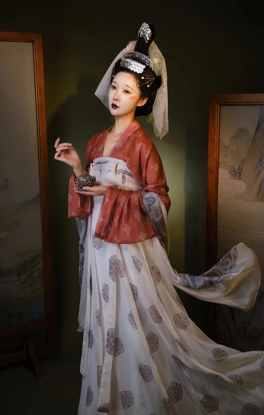 一个穿着传统服装拿着茶杯的女人的雕像