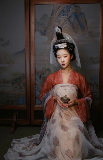一位身穿红白和服的年轻女子坐在一幅画前的肖像