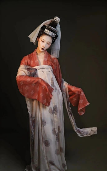 一个穿着红白相间连衣裙、撑着雨伞的女人的雕像
