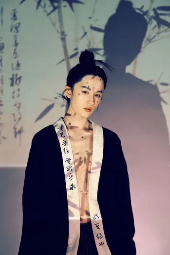 一位模特站在时装秀上 旁边是一位男士。