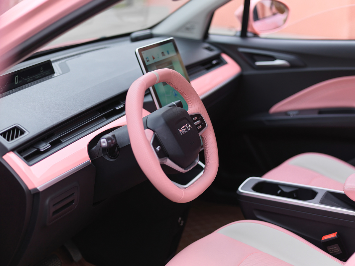 一辆带有粉红色座椅和粉红色方向盘的车。