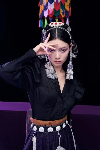 一位身着传统服装的年轻女子在舞台上摆姿势
