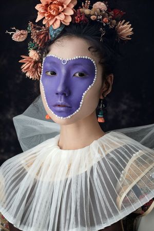 一位身着盛装 脸上饰有花卉图案 头戴面纱的女士的肖像