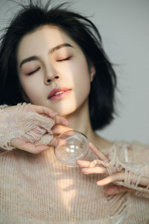 一位年轻女子双手握着一只玻璃杯 闭着眼睛