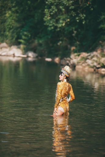 一位美丽的年轻女子站在湖边的水体中