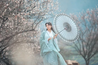 一位穿着传统蓝色和服的美女手持雨伞